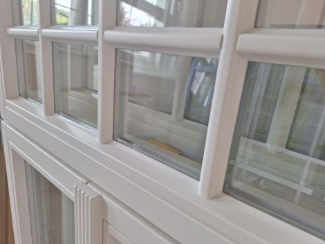 Weiße Holzfenster aus Eiche mit individueller Schlagleiste und Oberlicht mit Fenstersprossen