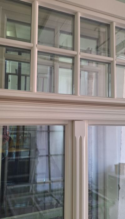 Weiße Holzfenster aus Eiche mit individueller Schlagleiste und Oberlicht mit Fenstersprossen