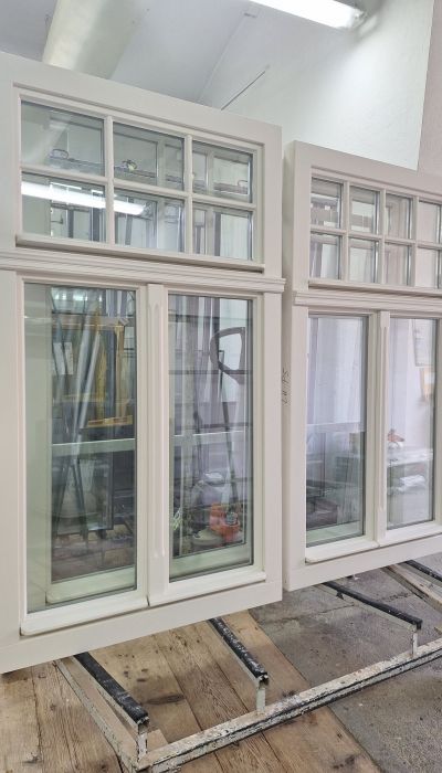 Weiße Holzfenster aus Eiche mit individueller Schlagleiste und Oberlicht mit Fenstersprossen