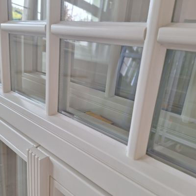 Weiße Holzfenster aus Eiche mit individueller Schlagleiste und Oberlicht mit Fenstersprossen