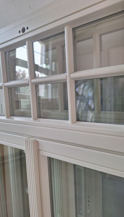 Weiße Holzfenster aus Eiche mit individueller Schlagleiste und Oberlicht mit Fenstersprossen