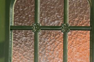 Glas mit Blumen in der Jugendstiltür