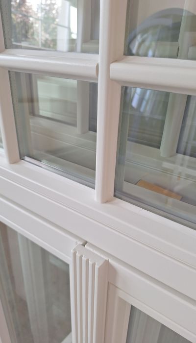 Weiße Holzfenster aus Eiche mit individueller Schlagleiste und Oberlicht mit Fenstersprossen